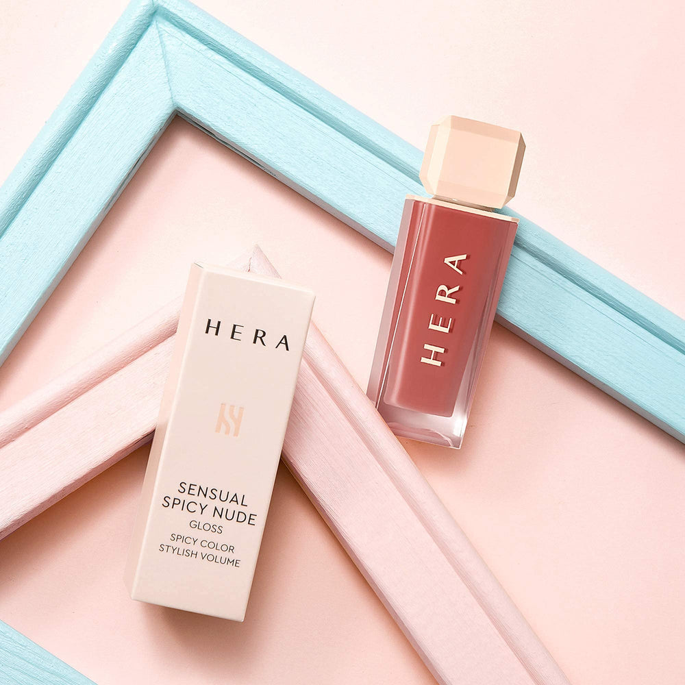 Packaging shot of HERA Lip Gloss emphasizing premium Korean beauty branding.