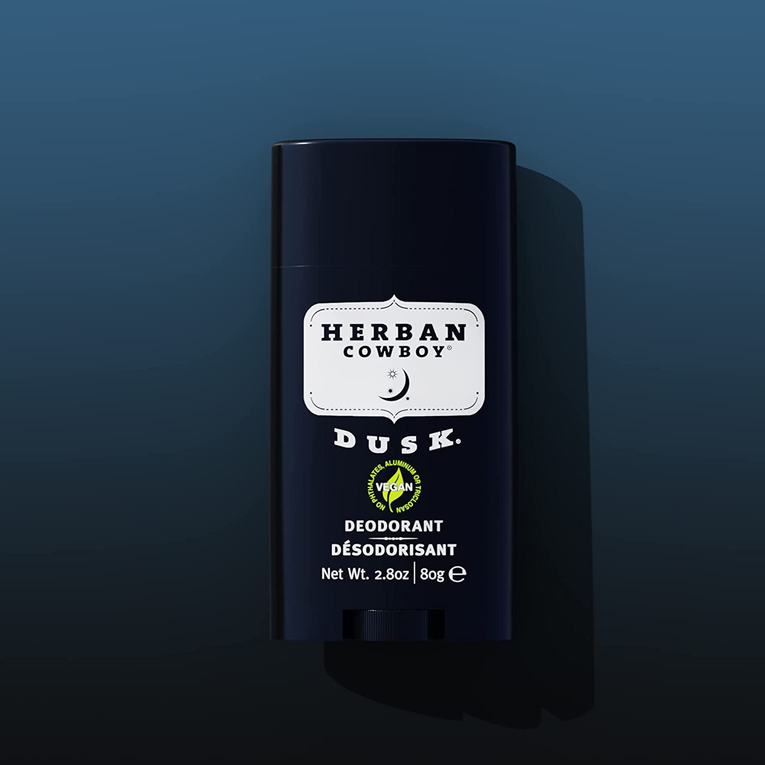 Hand using Herban Cowboy DUSK deodorant stick for quick application.