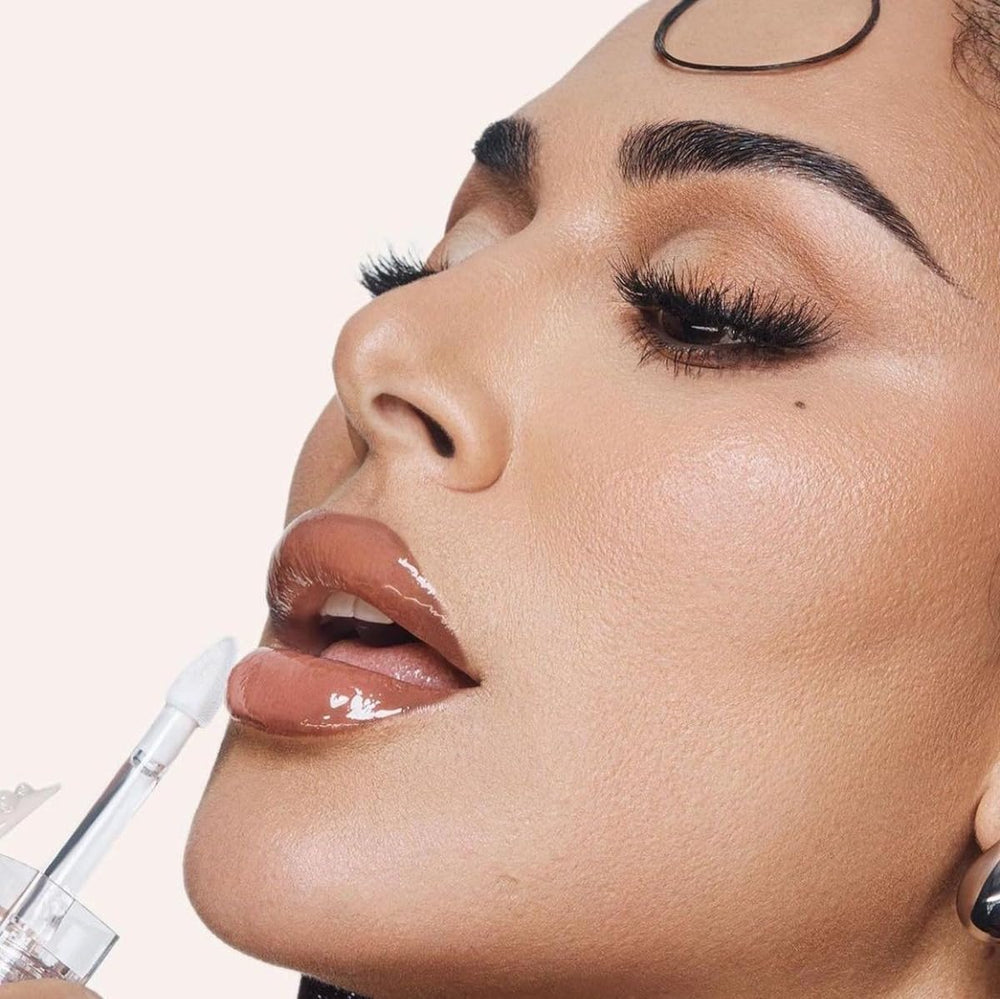 Huda Faux Filler Extra Shine Lip Gloss Glassy forearm swatch shows even clear coverage