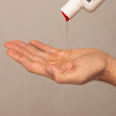 ISDIN Lambdapil shampoo being poured showing cleansing action for daily use