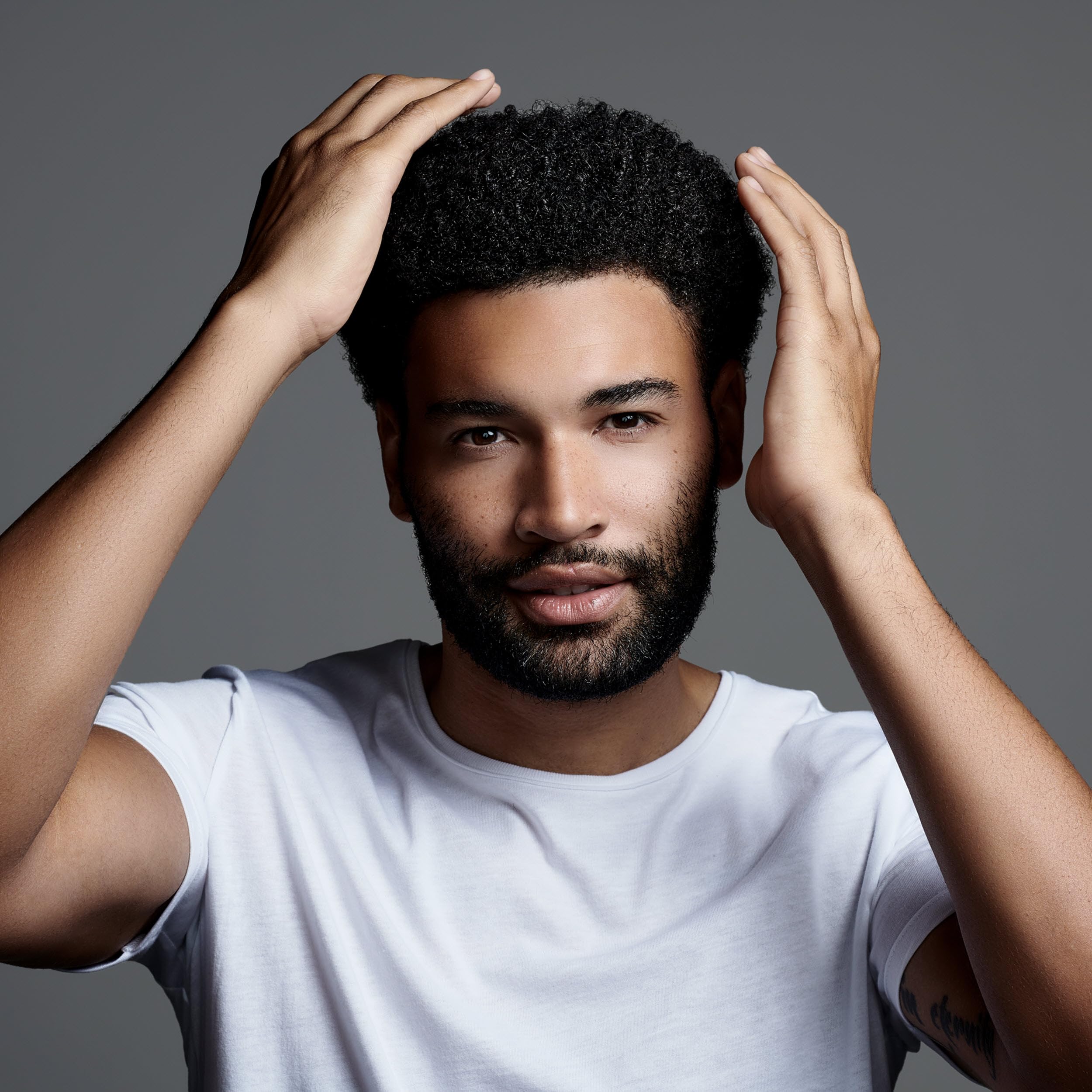 Styling hair with Jack Black Clay Pomade for texture and definition.