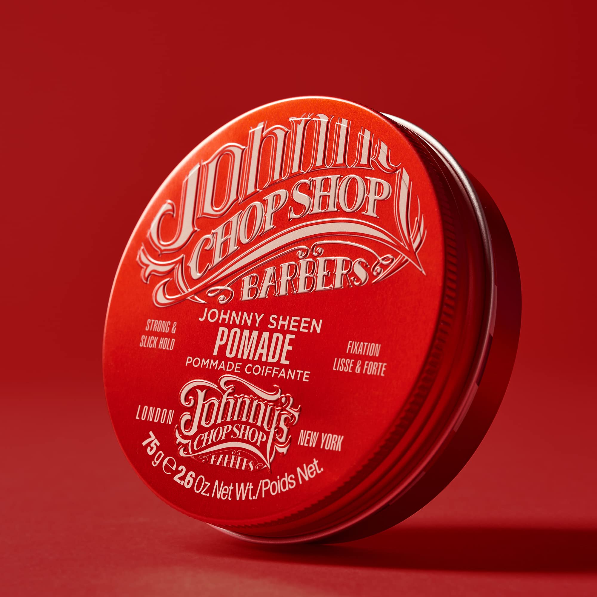 Johnny's Chop Shop pomade label close-up highlights high-shine formula for smooth style.