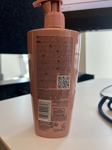 Hand with lather from Kerastase Chroma Absolute ready for distribution