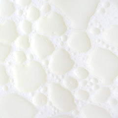 KORA Organics Milky Mushroom Oil Cleanser being shaken to activate creamy milk texture.