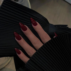 KQueenest burgundy nails on finger highlighting glossy stiletto shape