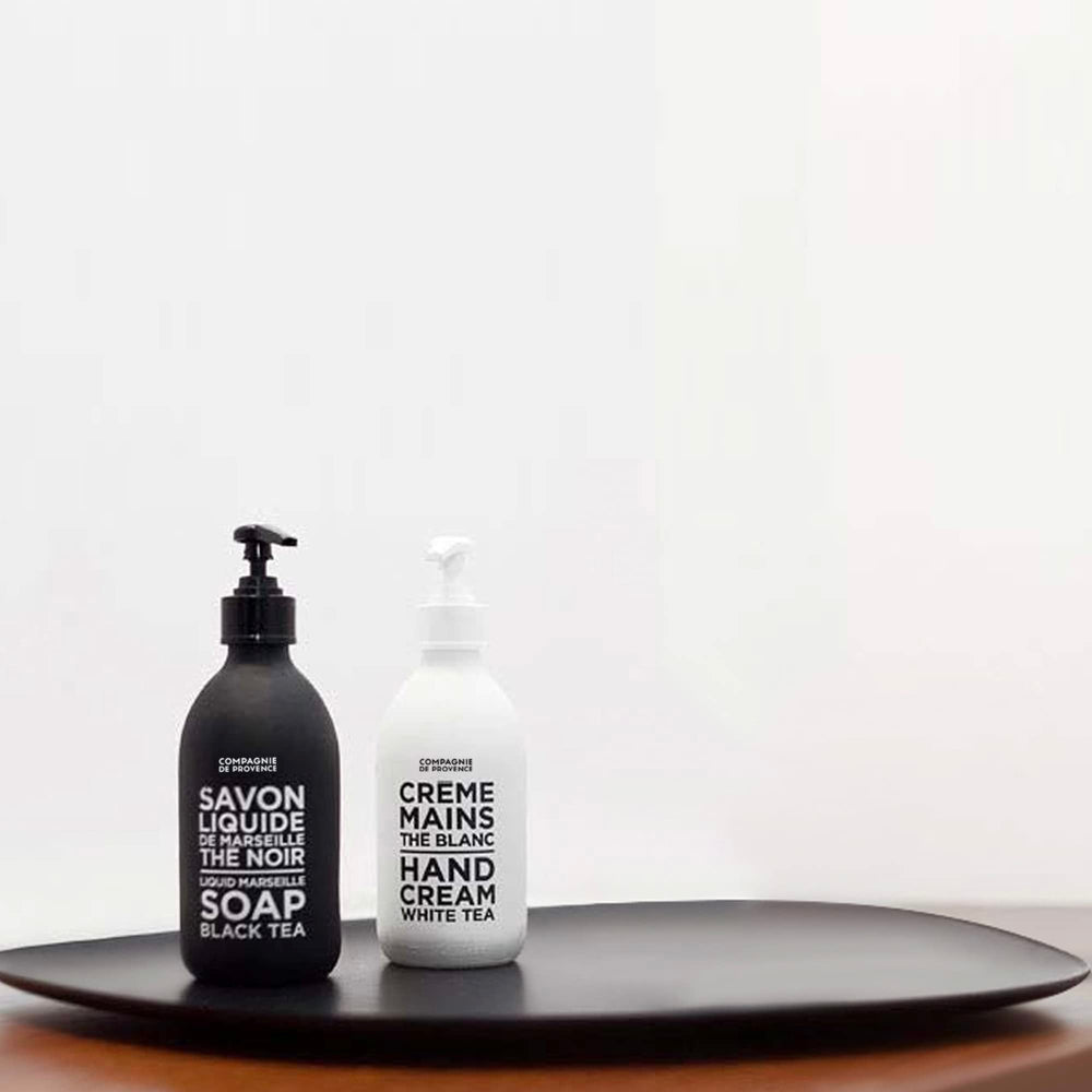 La Compagnie de Provence glass bottle with pump in modern bathroom.