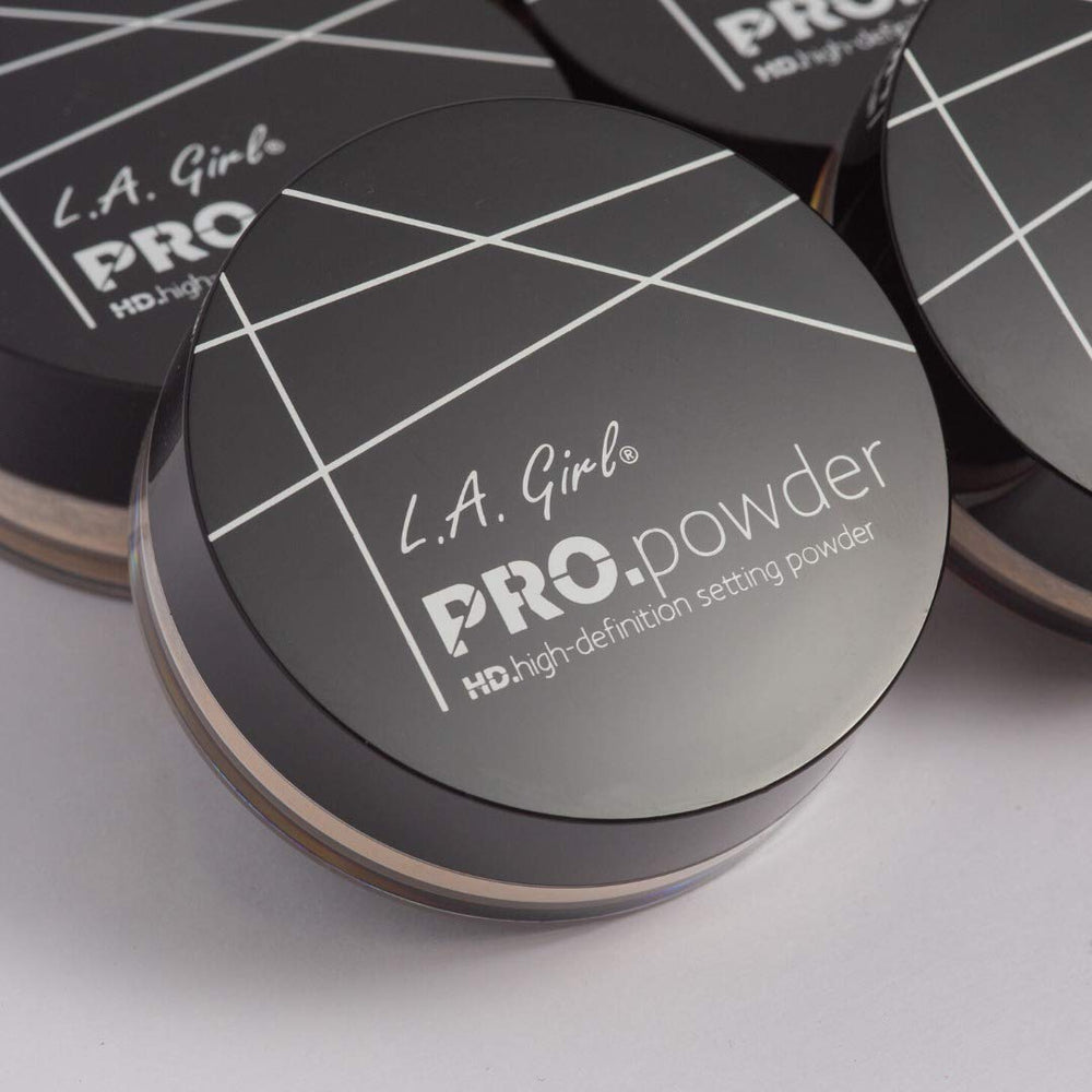 Hands applying L.A. Girl BB Pro Powder translucent with brush