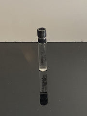 A swatch next to the bottle to explore the fragrance's airy, woody-musk vibe.