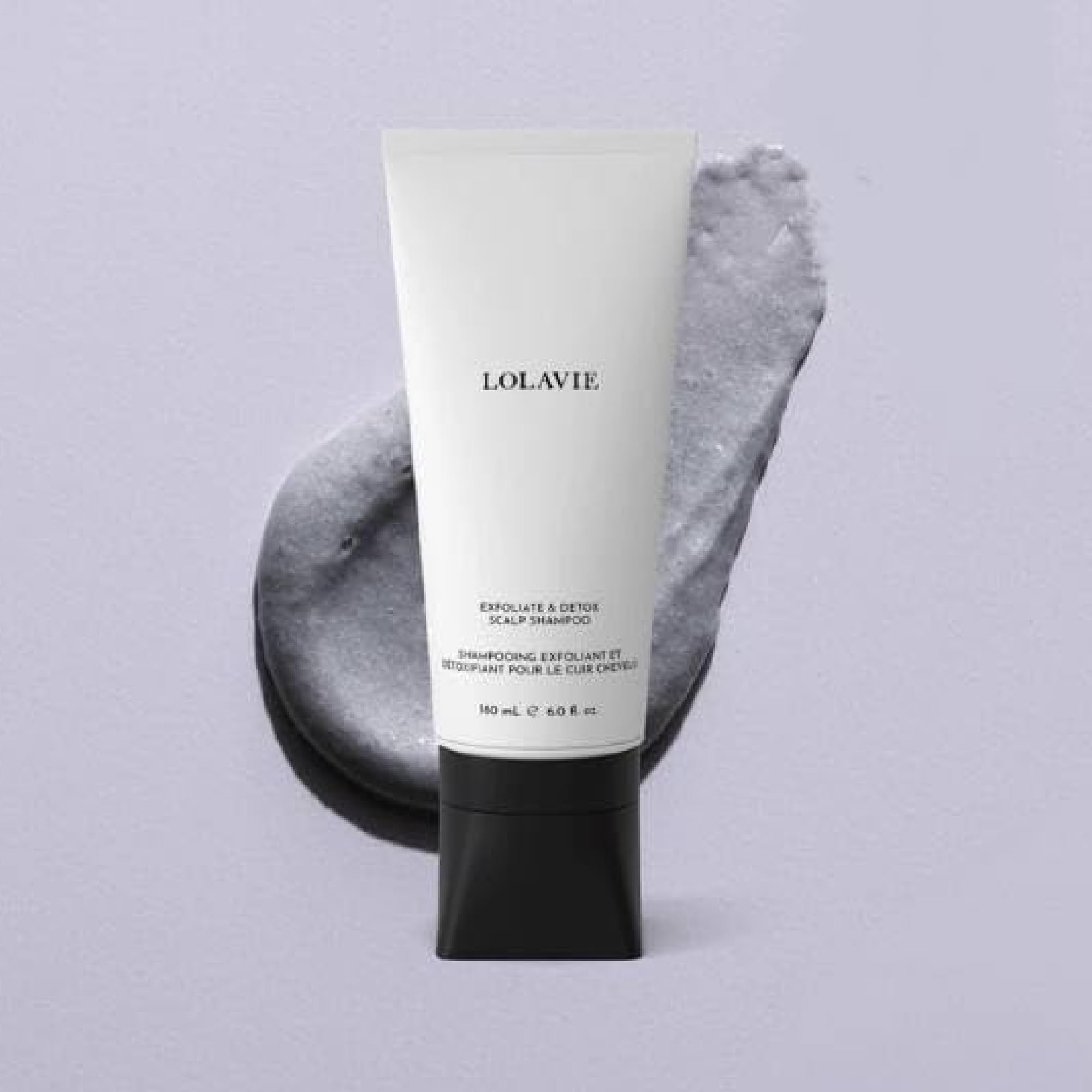 LolaVie Exfoliate & Detox scalp scrub in hand highlights charcoal exfoliation benefits.