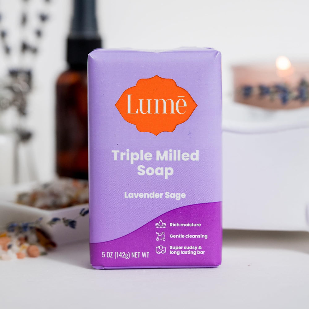 Lume bar soap in use with bubbles and gentle cleansing under running water.
