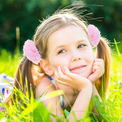 Lusofie pink pompom hair tie worn on the wrist as a decorative accessory
