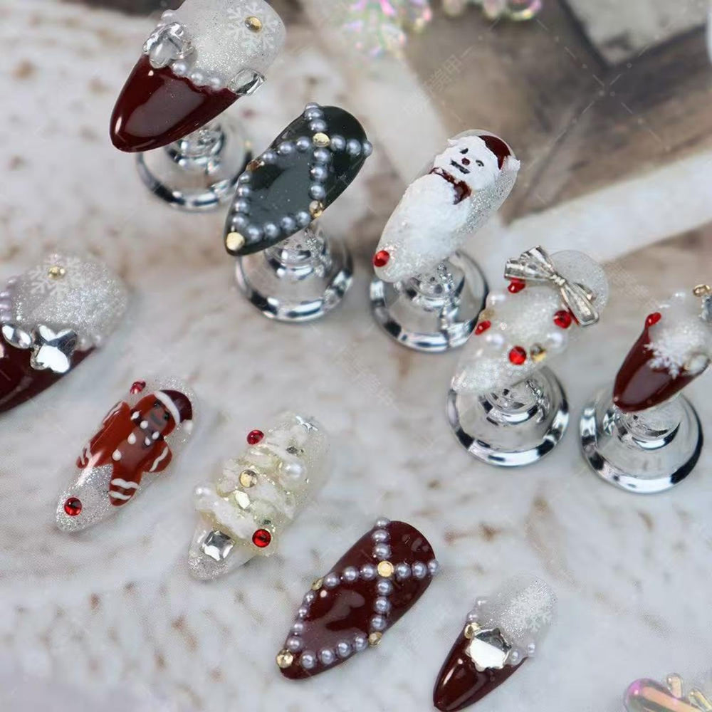 Maigitur nails showcase gingerbread man detail on dark red almond tips for playful style.