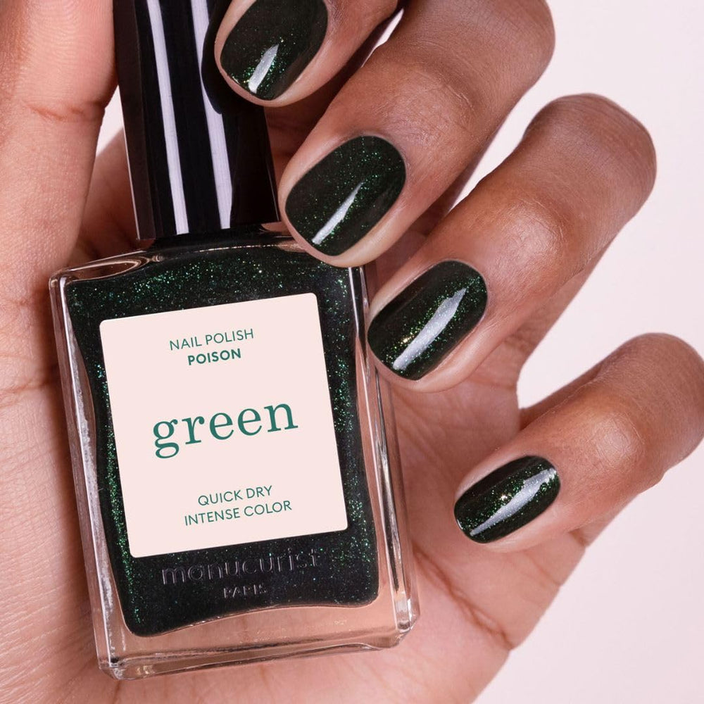 Poison glitter on nail shows opaque, sparkling forest-green finish.