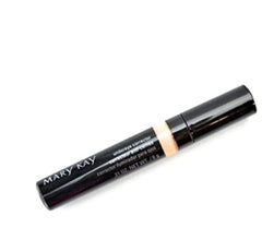 Mary Kay Under Eye Corrector tube applying creamy formula to conceal dark circles.