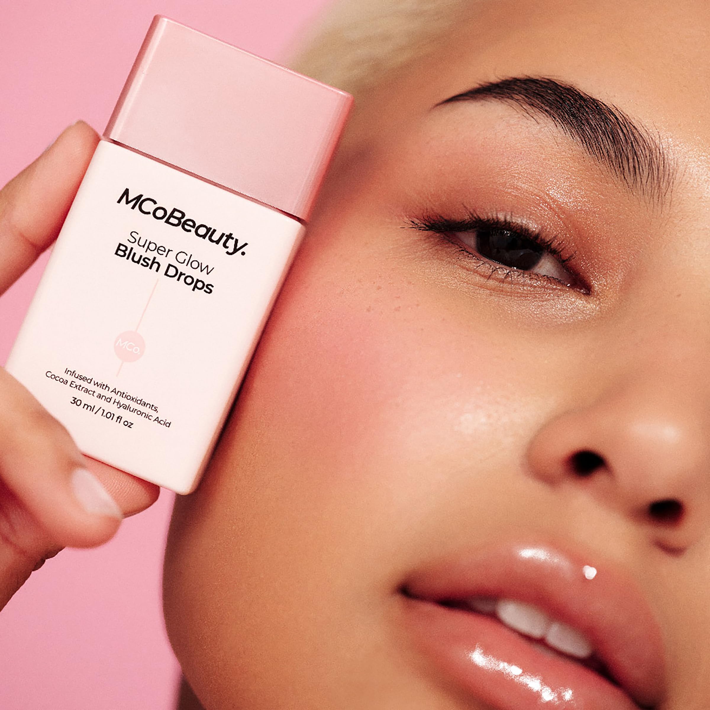 Hand-held bottle of MCoBeauty Super Glow Blush Drops for on-the-go glow.