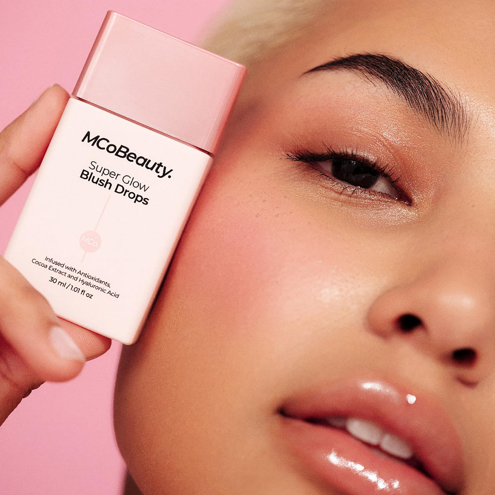 Hand-held bottle of MCoBeauty Super Glow Blush Drops for on-the-go glow.
