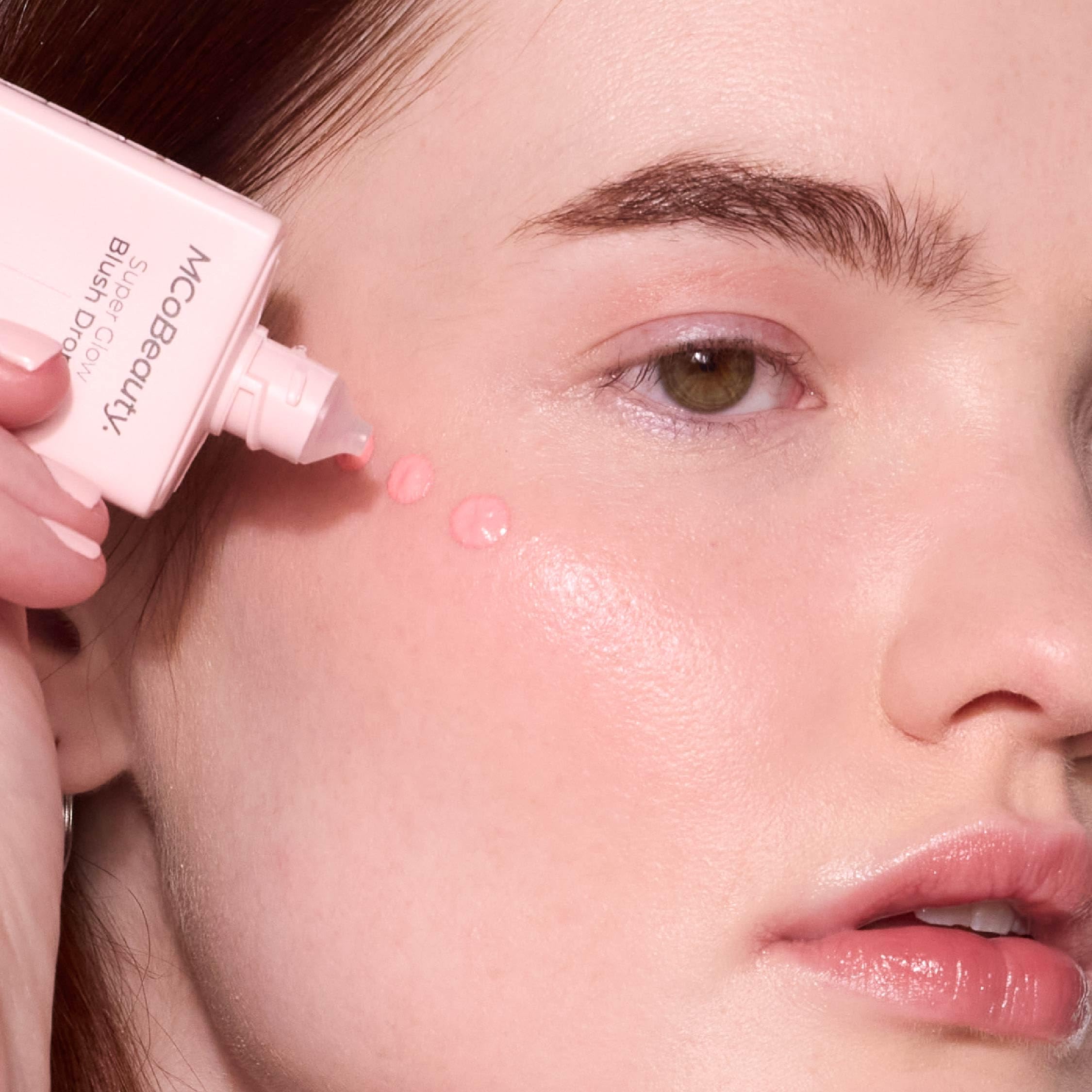 MCoBeauty blush drops applied to cheek for buildable shine