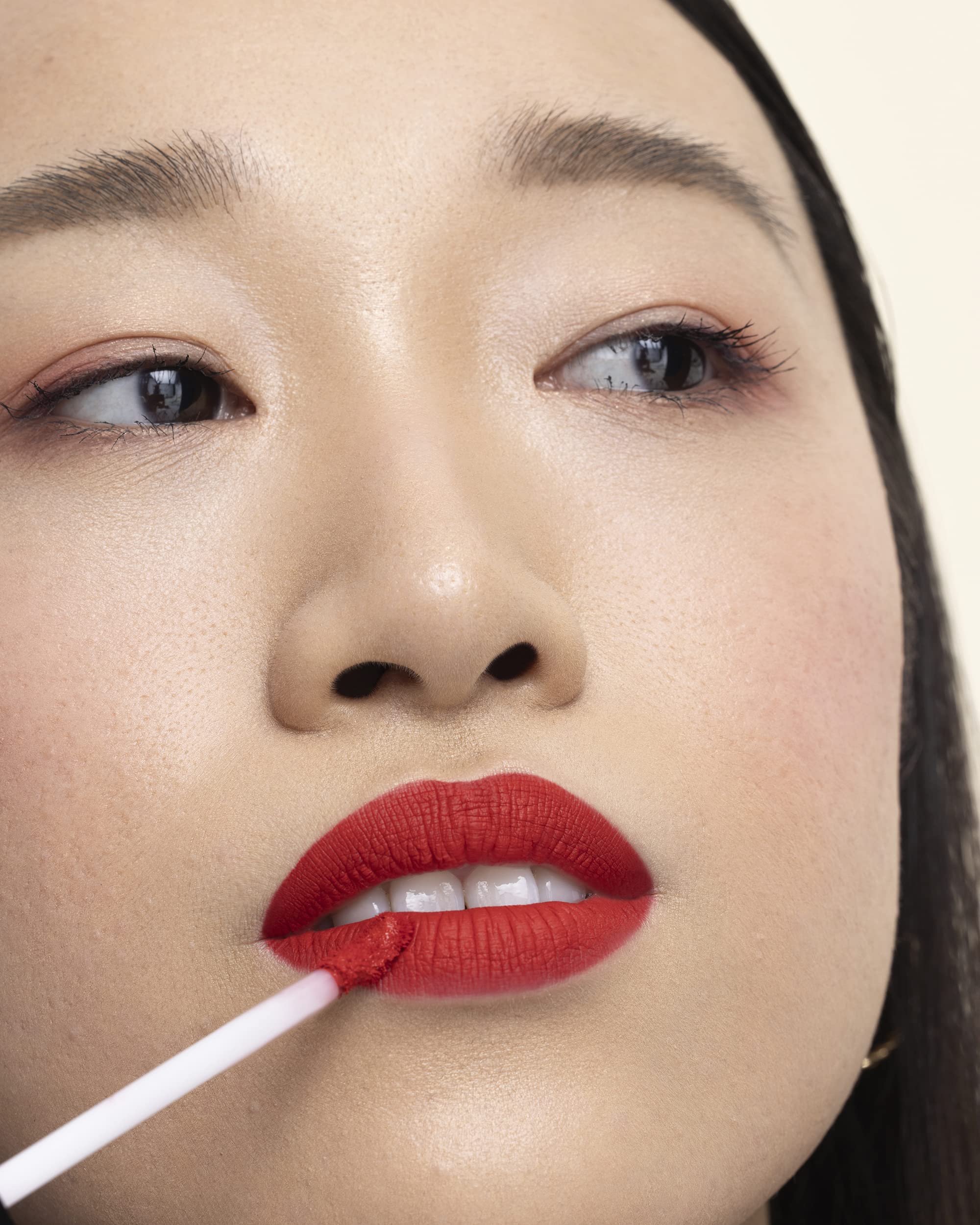 Applying Milani Stay Put Liquid Lipstick with the doe-foot for even coverage.