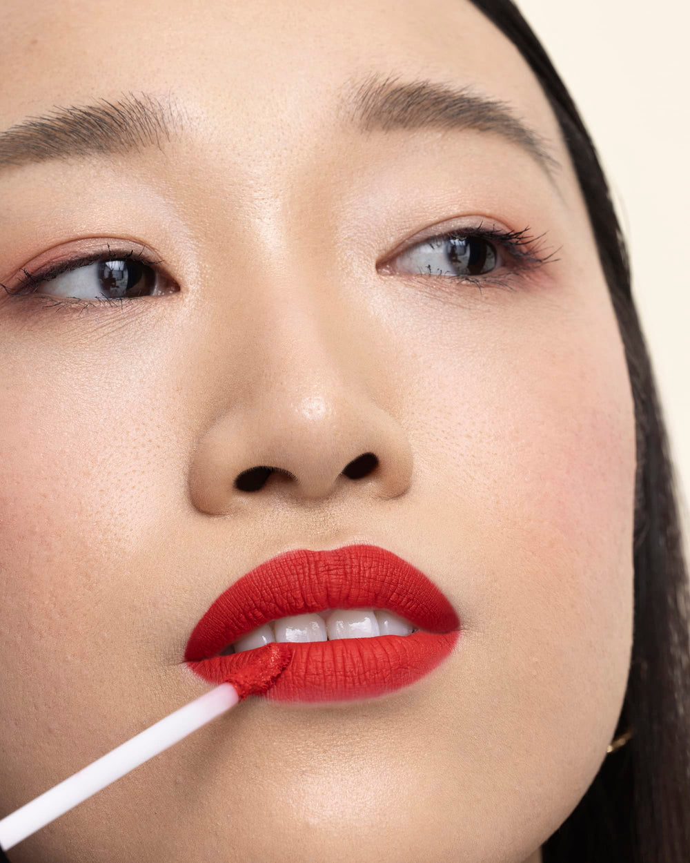 Applying Milani Stay Put Liquid Lipstick with the doe-foot for even coverage.