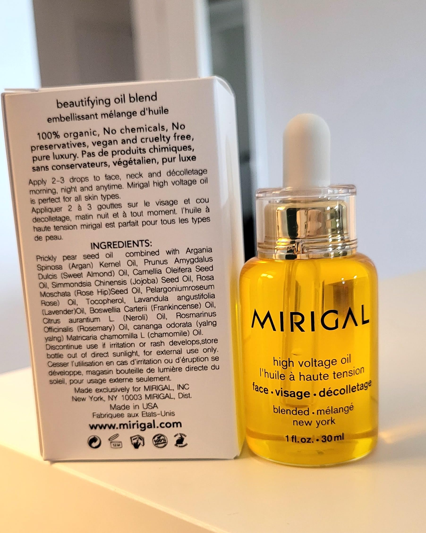 MIRIGAL High Voltage Oil bottle paired with natural botanicals and oils