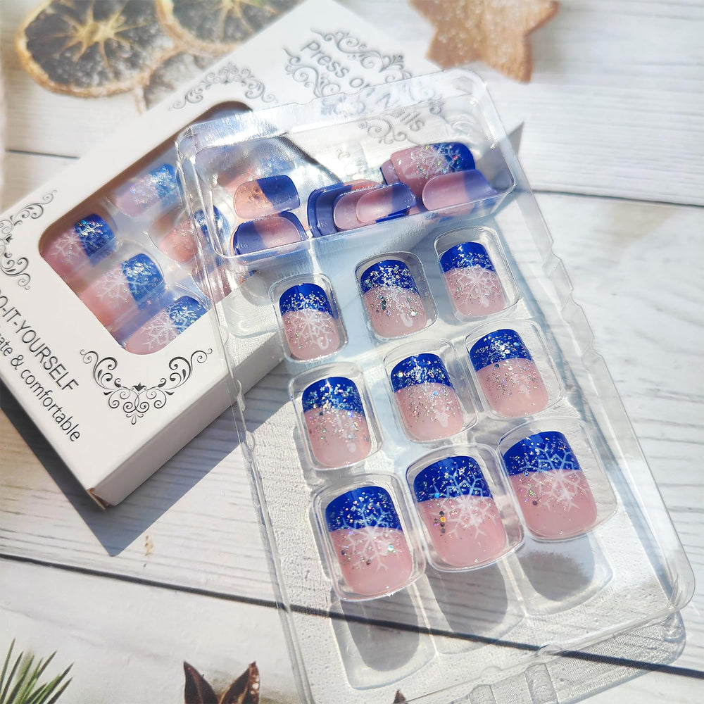 Blue French tip nails by Mkwntg with glossy finish and snowy accents for winter style.
