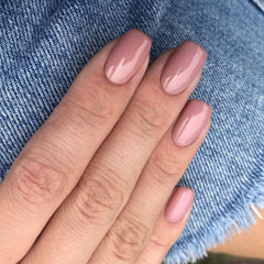 Close-up of peach pink short square press-on nails for quick glam upgrade.