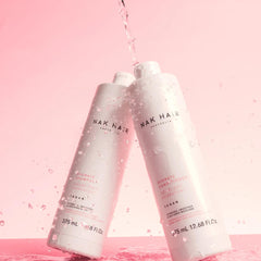A rich lather from NAK Hair Hydrate Shampoo in hand, cleansing dehydrated hair gently.