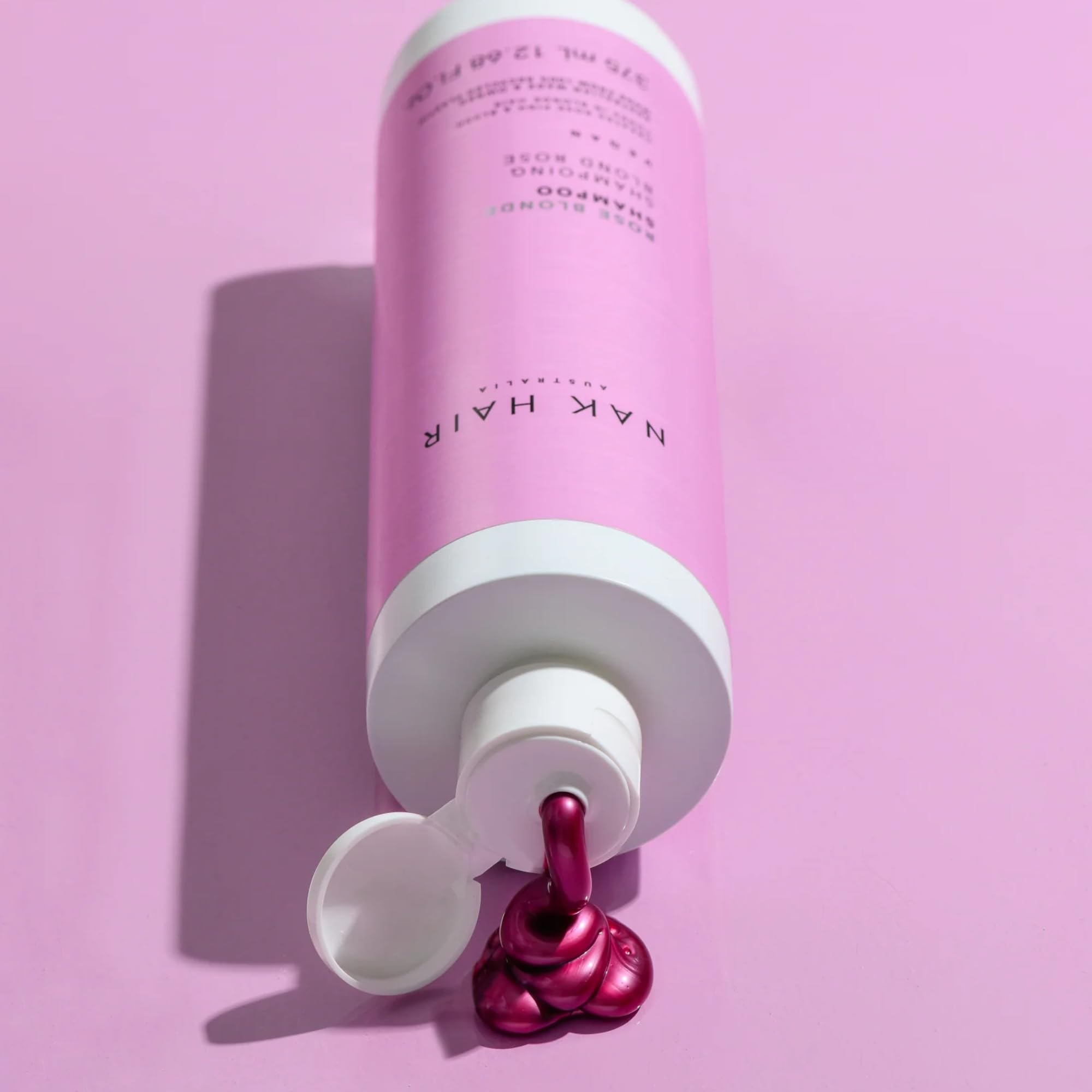 NAK Rose Blonde Shampoo applied shows subtle rose blush tint on strands.