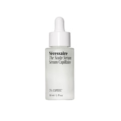 Nécessaire Scalp Serum pipette dispensing on a glass bottle for precise application on the scalp.