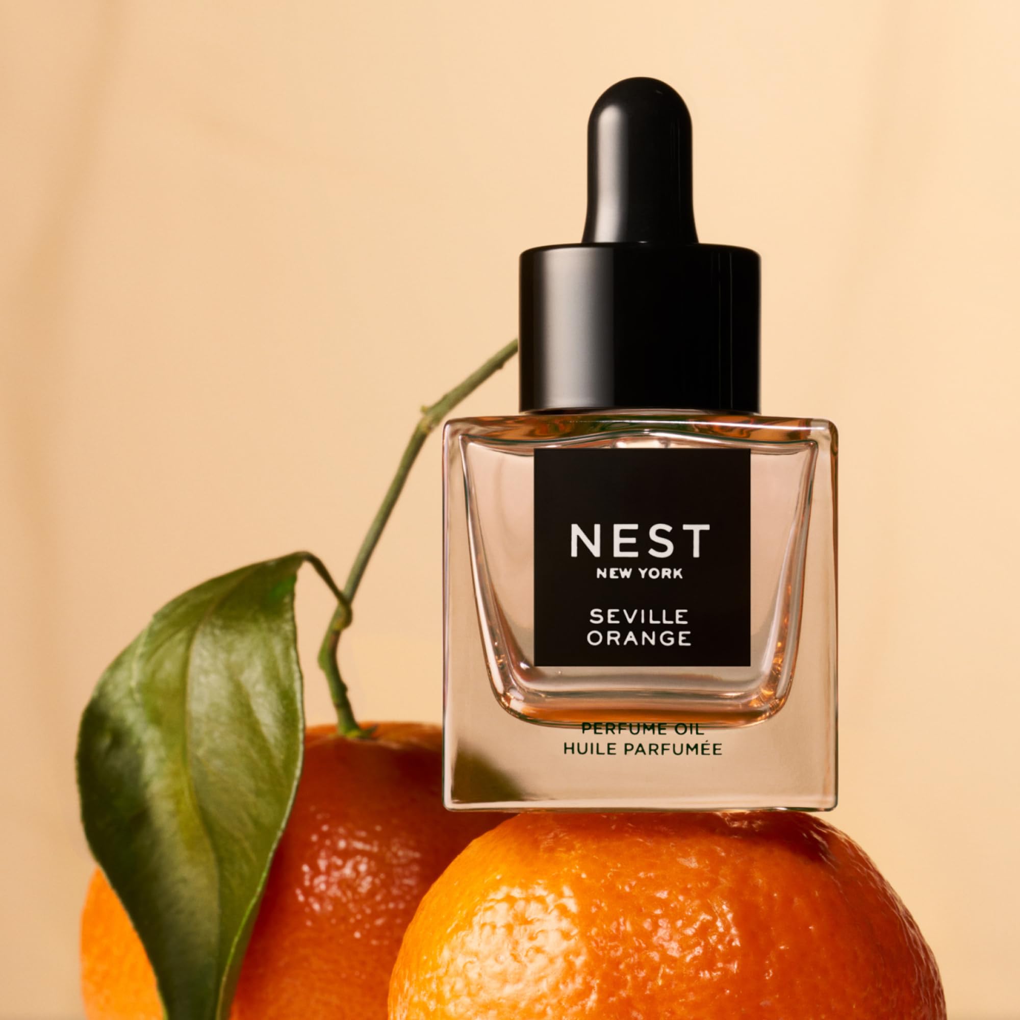 Close-up of Seville Orange bottle showing vibrant orange hue and luxury dropper.