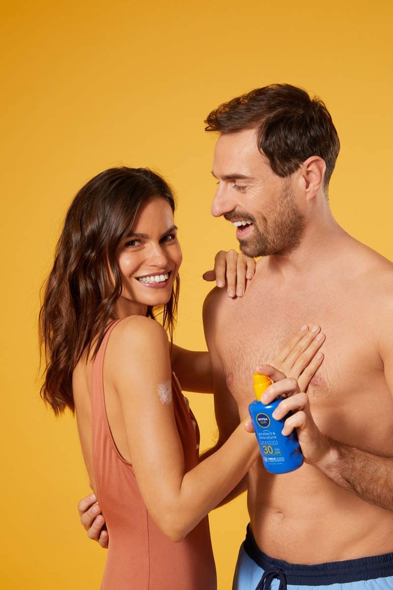 Adult enjoying sunny day with NIVEA SPF30 spray.