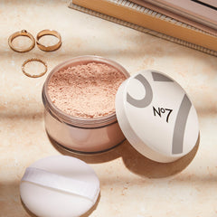 Fluffy brush applying No7 Flawless Finish loose powder for a matte finish.