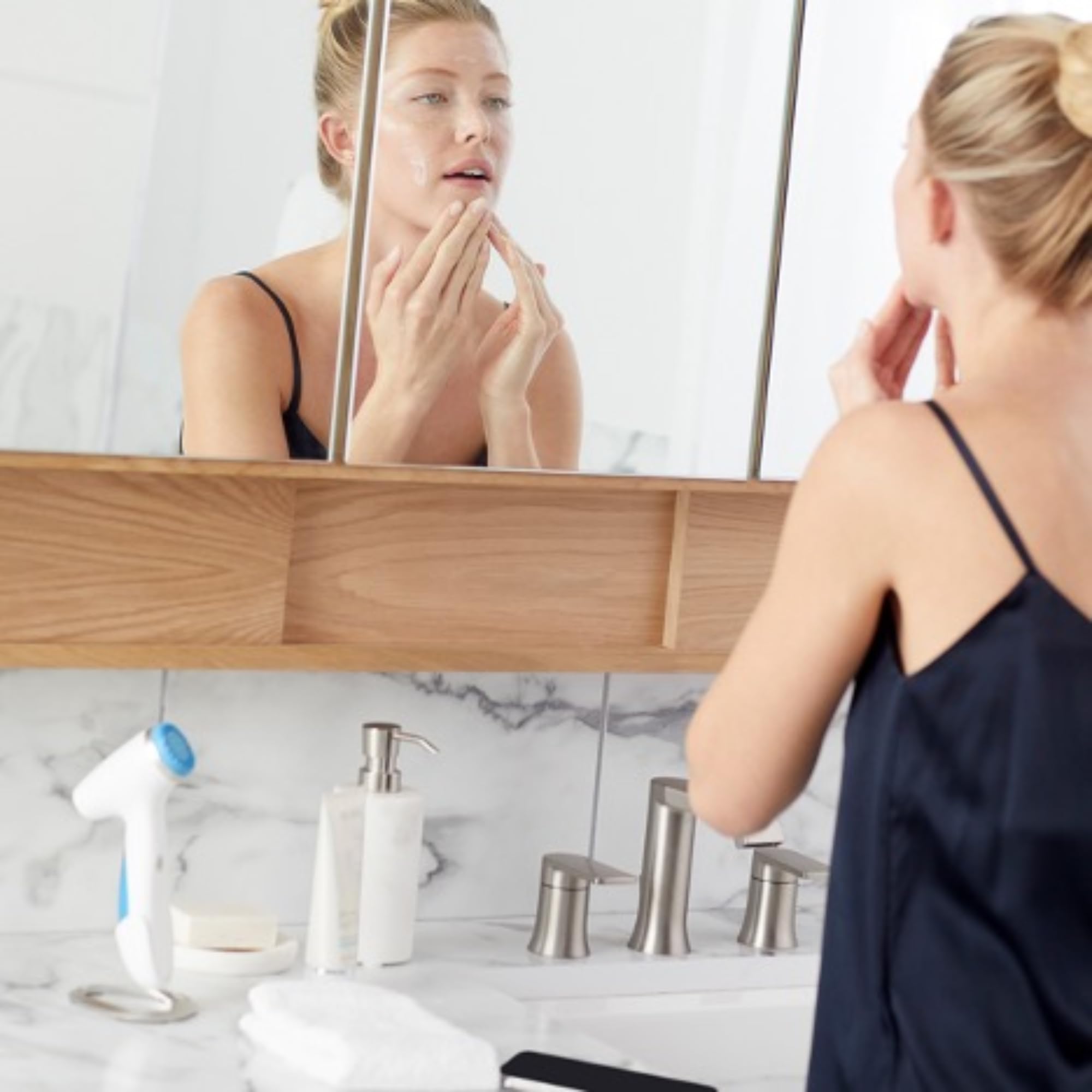 Applying Nu Skin ageLOC LumiSpa cleanser on skin with LumiSpa device.