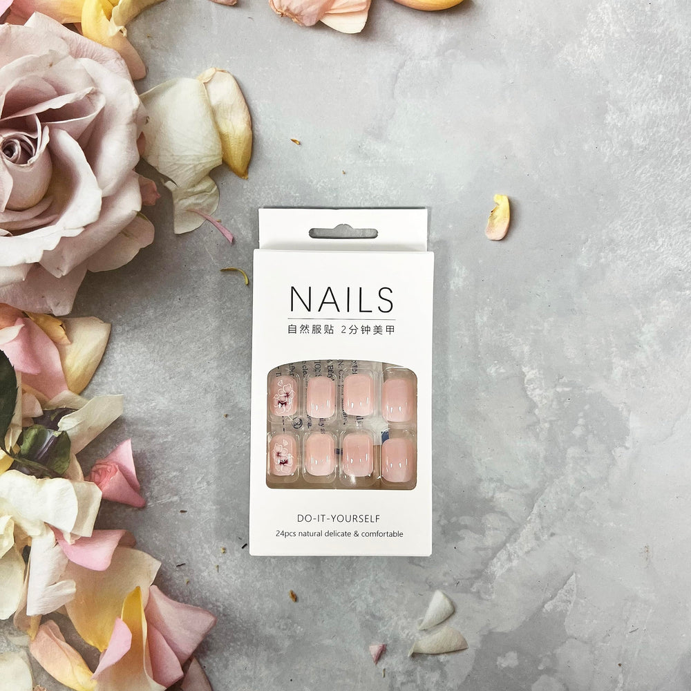 OCOUYVD nude-pink glossy nails with floral motifs for elegant looks.