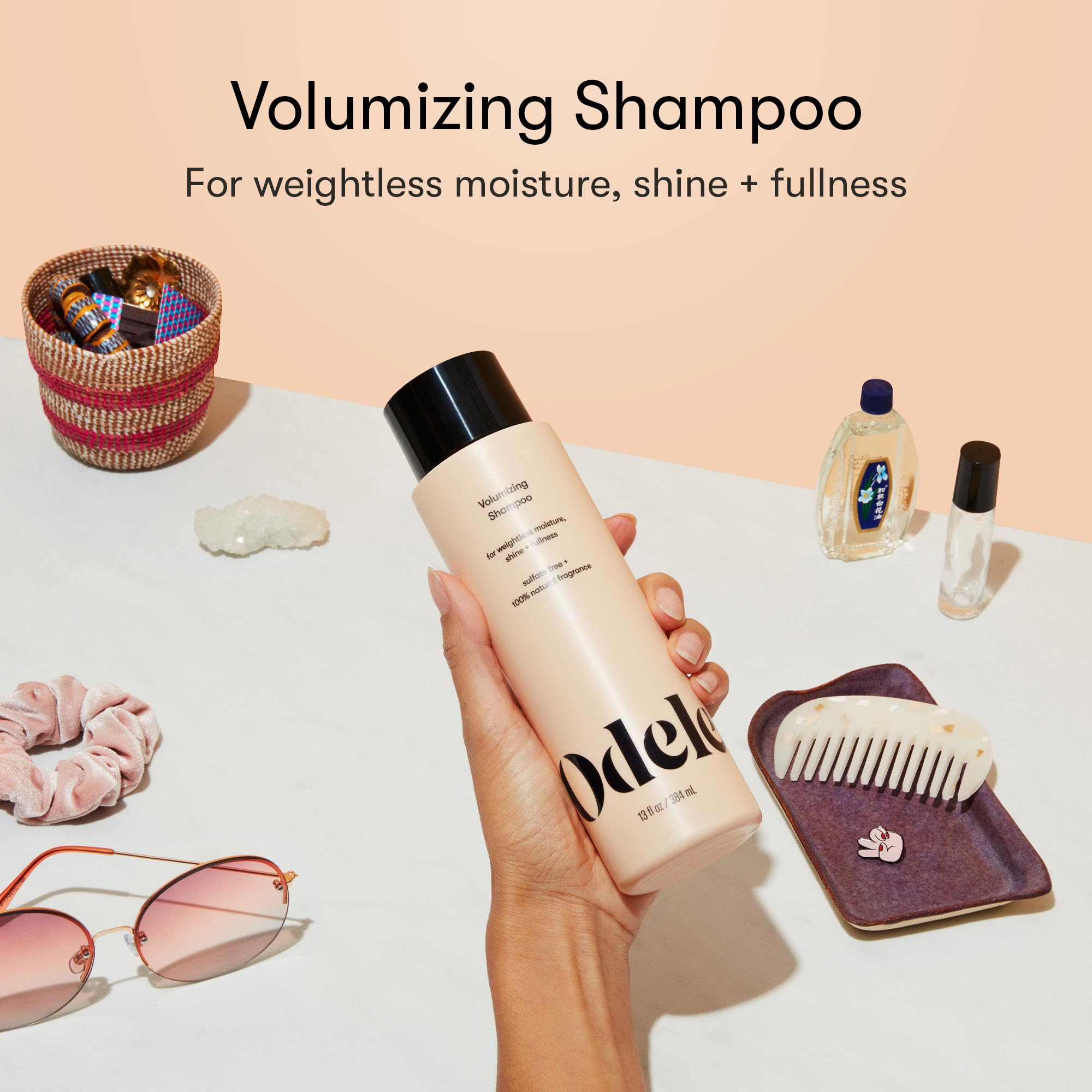 Pouring Odele Volumizing Shampoo showing easy dispensing for balanced scalp care.