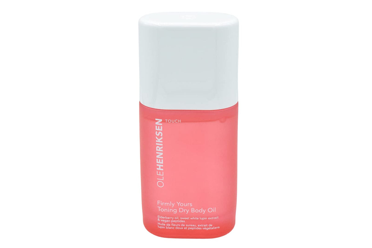 Ole Henriksen Firmly Yours dry body oil bottle ready for hydration on a bathroom shelf.