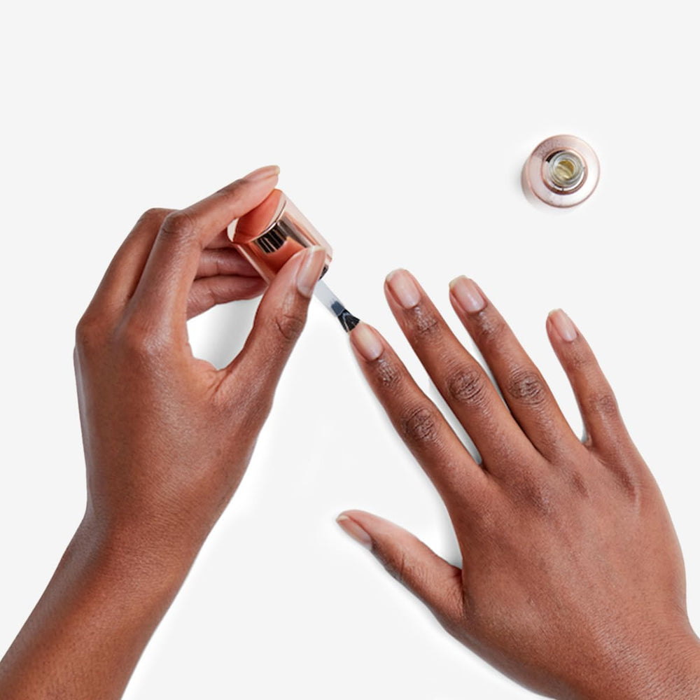 Application of Olive & June Nail Primer on nails for smoother polish.