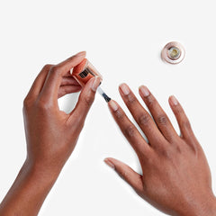 Application of Olive & June Nail Primer on nails for smoother polish.