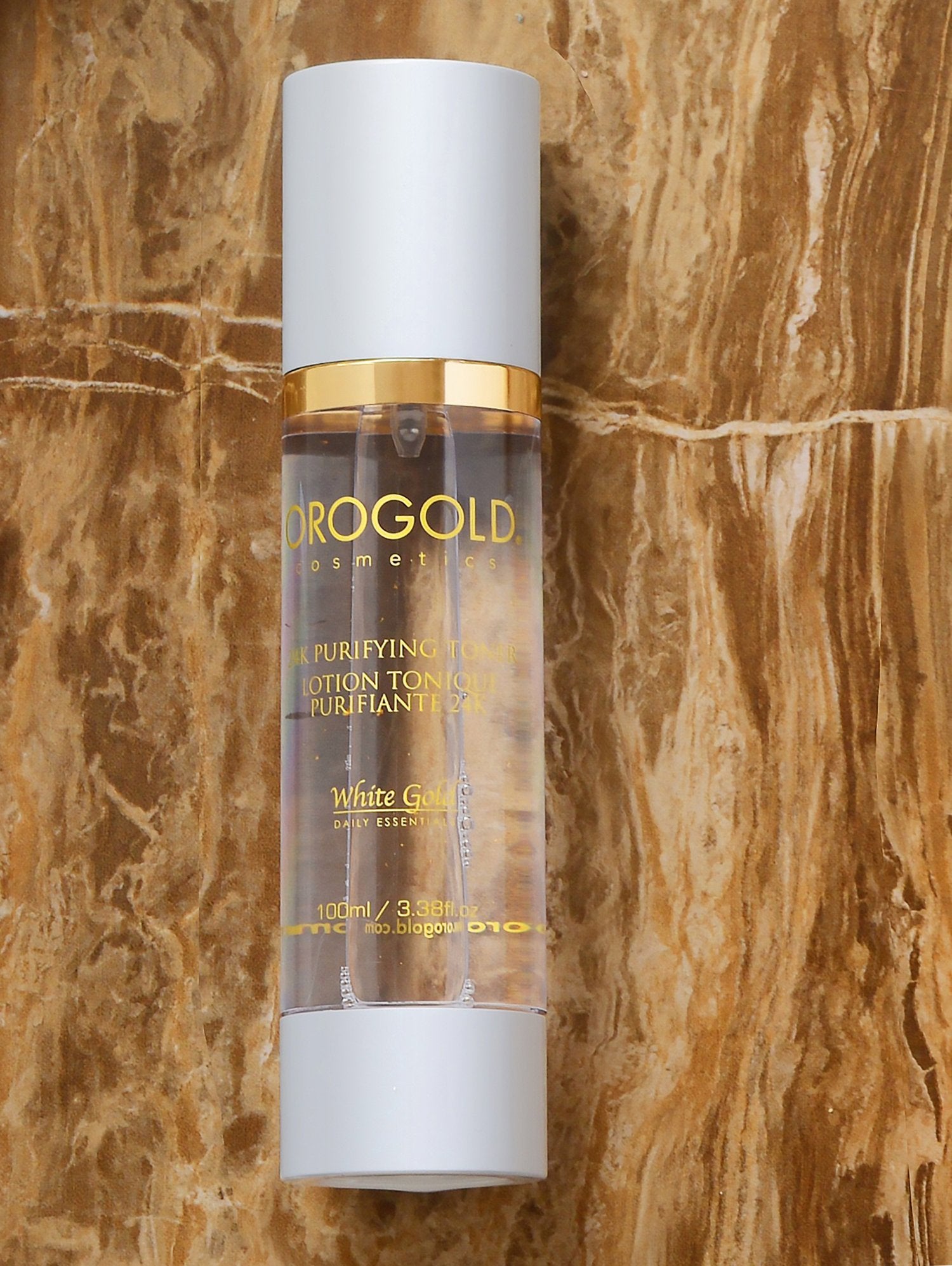 Orogold White Gold 24K Purifying Toner on a cotton pad ready for gentle application.
