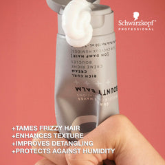 Hands applying OSiS+ Bounty Balm on damp hair for smoother detangling and texture
