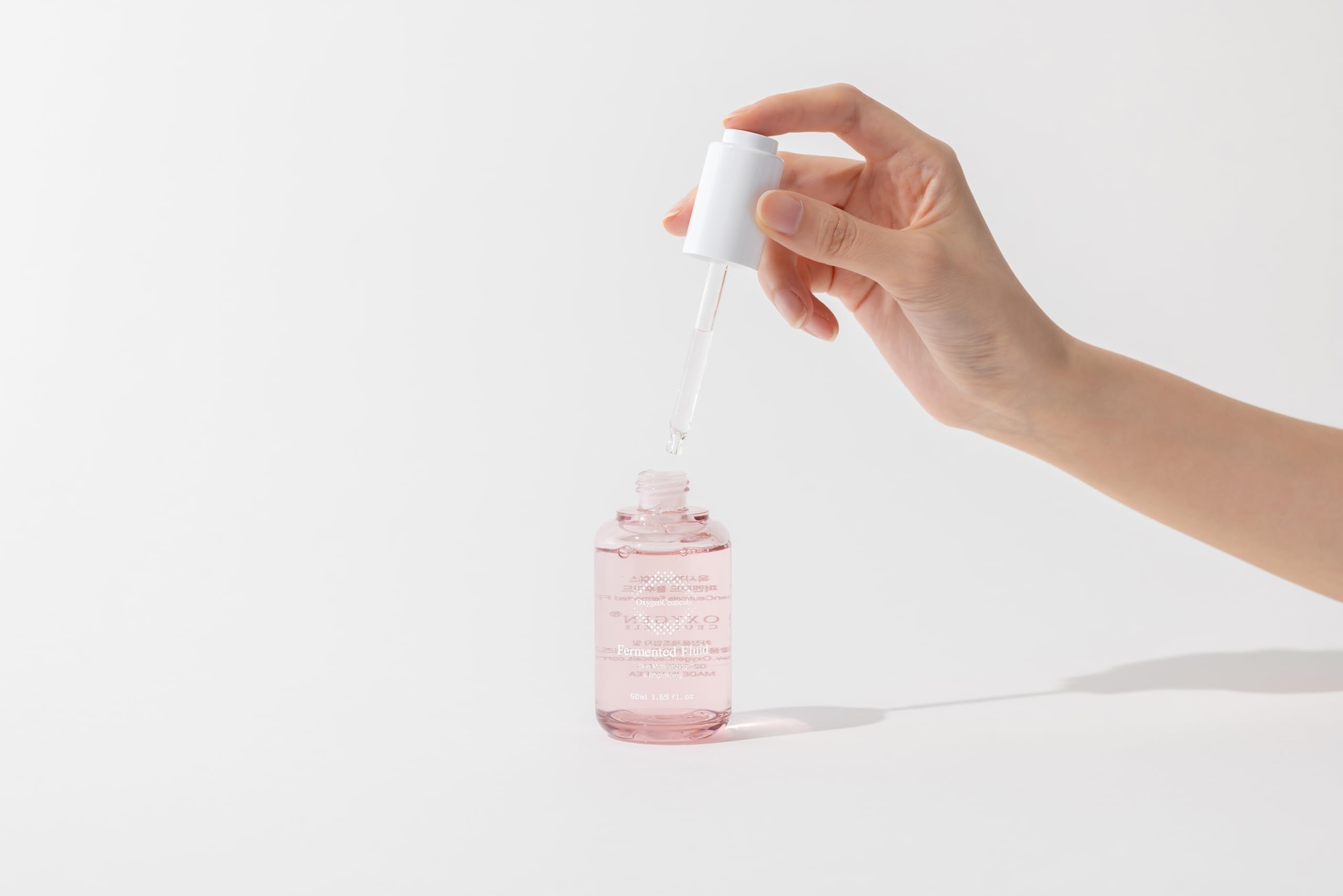 OxygenCeuticals Fermented Fluid tone-correction visual suggests a brighter appearance.