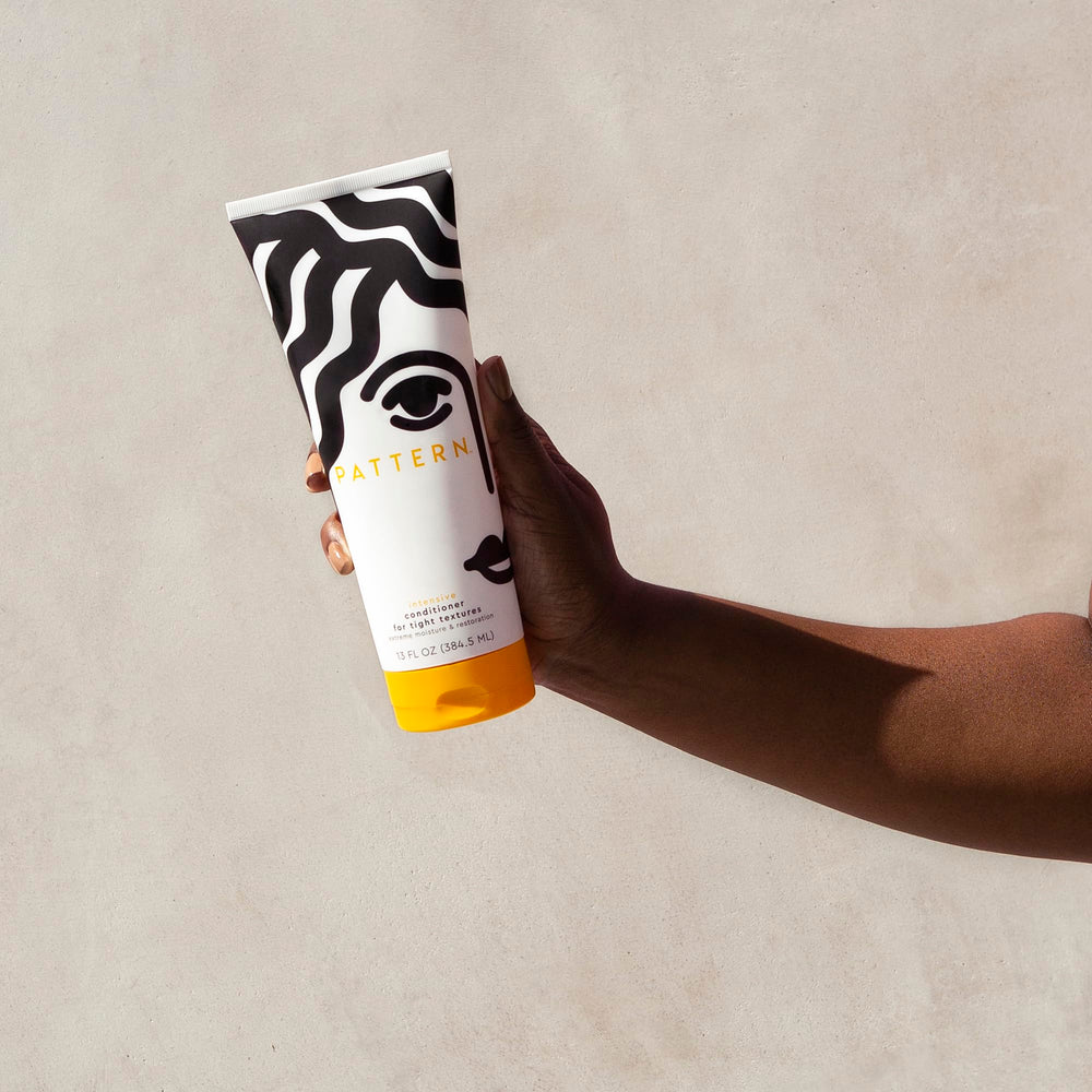 PATTERN Beauty Intensive Conditioner close-up on hair strands shows thick, creamy consistency.
