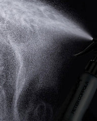 Close-up of mist being sprayed onto damp hair with Just Blow.