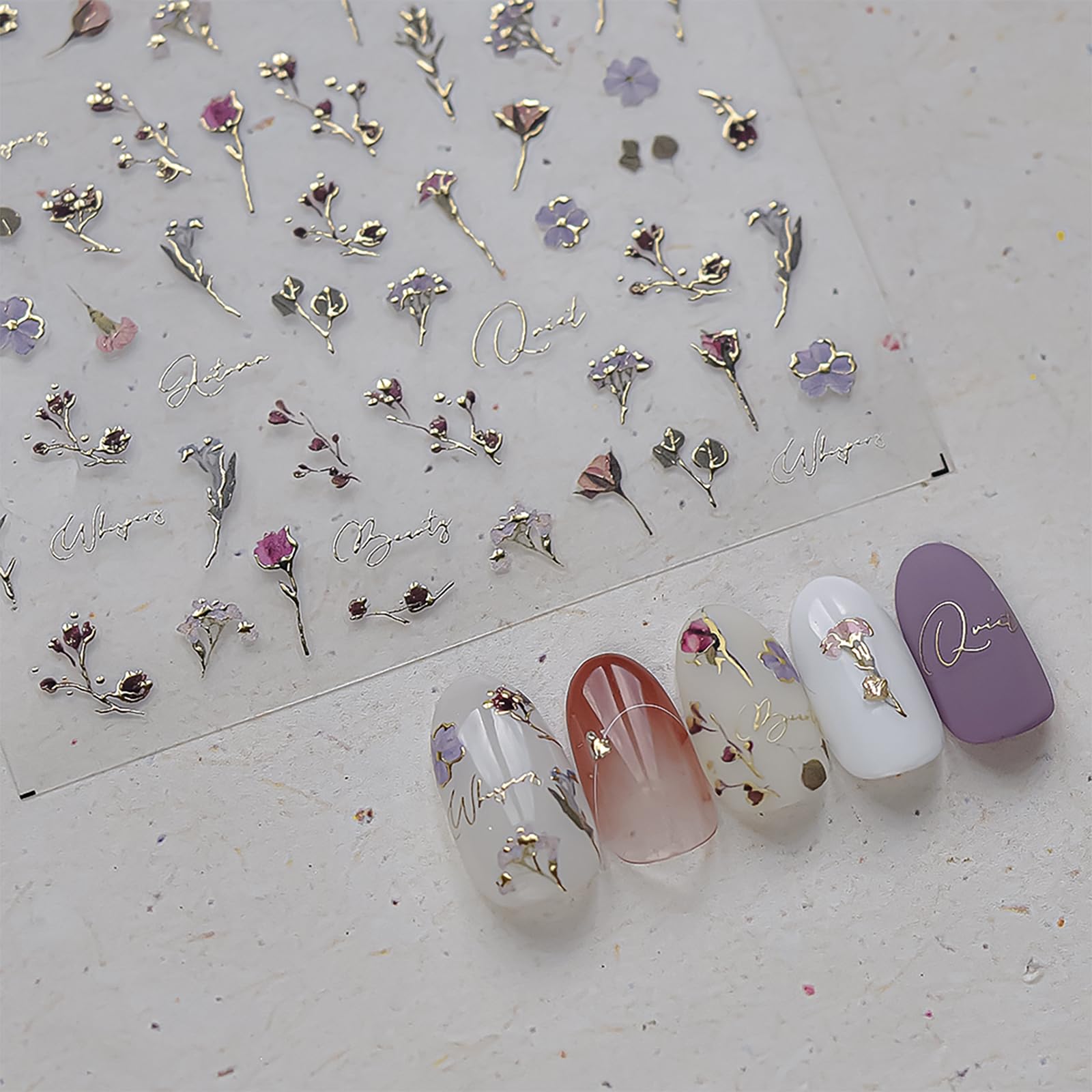 Gold-edged flowers add a luxe, reflective accent to manicure details.