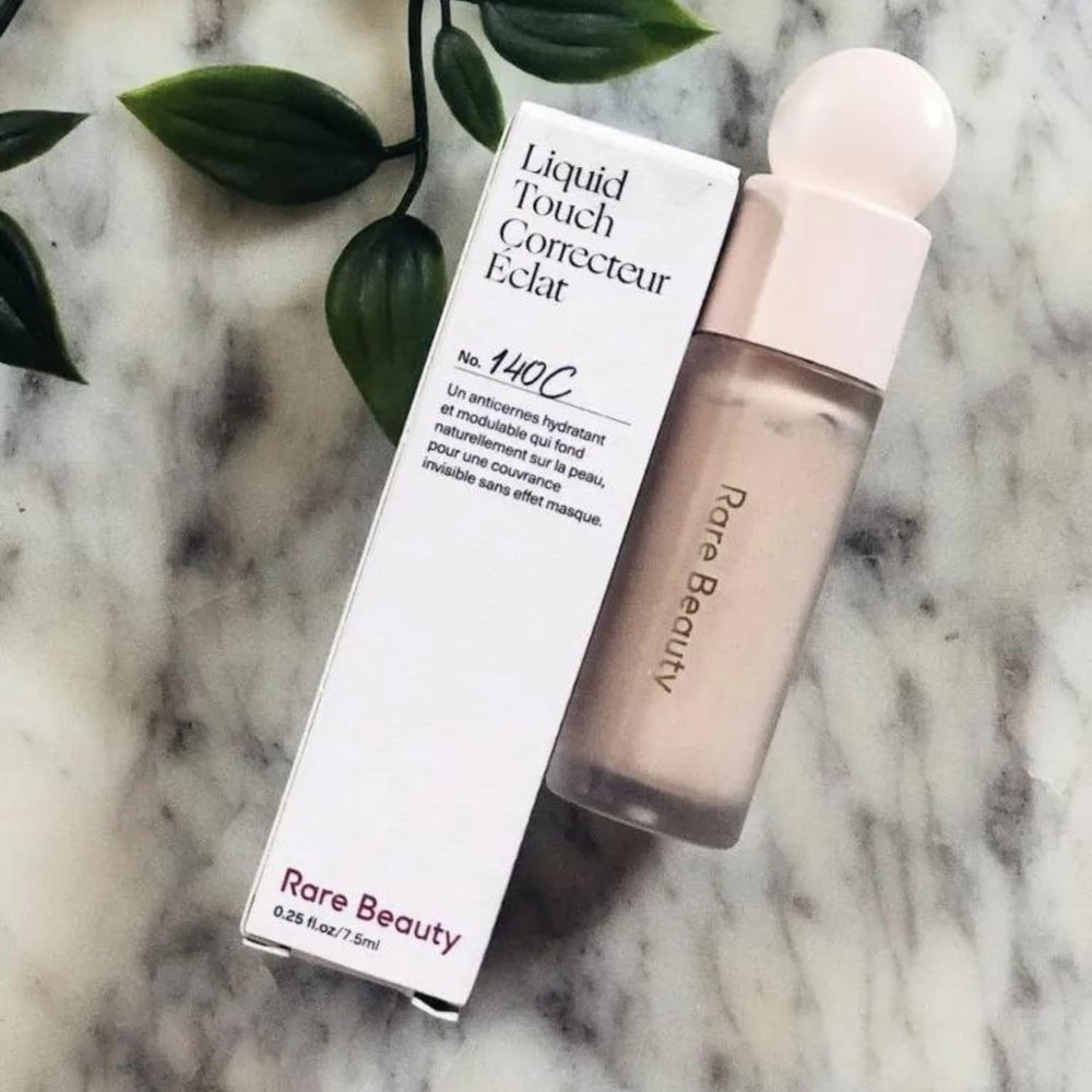 Rare Beauty Liquid Touch Brightening Concealer 140C application close-up showing creamy, blendable texture.
