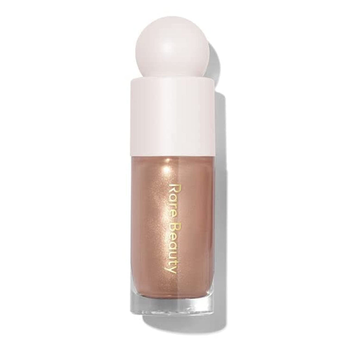 Rare Beauty Positive Light Luminizer Transcend bottle close-up showing luminous glow for instant radiance