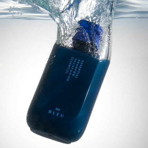 Hands holding R+Co BLEU bottle, hair looking smooth and glossy.