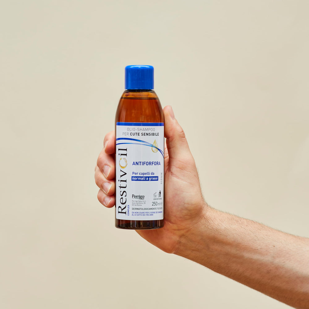 RestivOil bottle beside towel hints at refreshed scalp after wash.