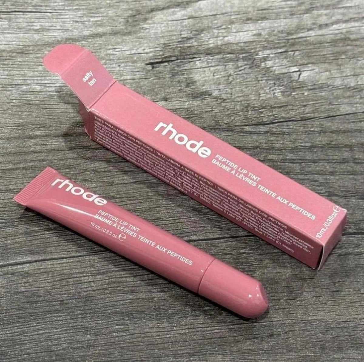 Rhode Peptide Lip Tint Salty Tan being applied for a hydrated glossy lip.