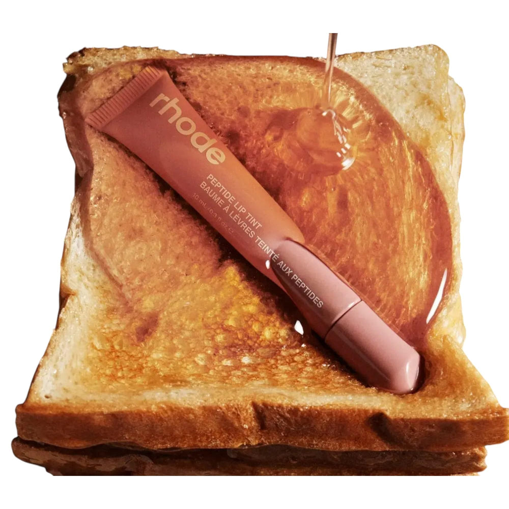Rhode peptide lip tint with sheer color layer builds intensity.